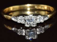 An 18ct gold ring set with three diamonds in a platinum setting, the largest approximately 0.2ct,