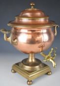 A heavy copper and brass twin handled samovar raised on ball feet, height 42cm