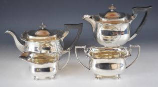 George V hallmarked silver four piece tea set with shaped gadrooned edges, each raised on four feet,