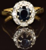 An 18ct gold ring set with a round cut sapphire surrounded by diamonds, 4.2g, size K