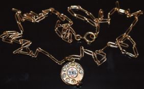 A 9ct gold charm/ pendant in the form of a telephone set with enamel reading '2 tel U I love you' on