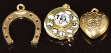 A 9ct gold charm in the form of a telephone with enamel reading '2 tel u I love you' (2g), a 9ct