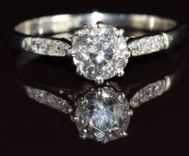 A platinum ring set with an old cut diamond of approximately 0.8ct and three diamonds to each