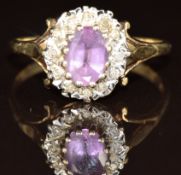 A 9ct gold ring set with an oval cut amethyst surrounded by diamonds, 2.3g, size P