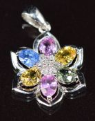 A 9ct white gold pendant set with diamonds and pink, yellow, green and blue sapphires in a floral