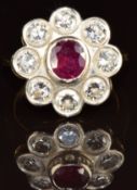 An 18ct gold ring set with an oval cut ruby of approximately 0.8ct surrounded by eight diamonds,