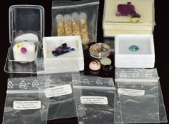 A collection of loose gemstones including ruby, opal, garnet, diamonds, enhanced blue diamonds,