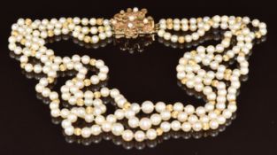 A three strand necklace made up of cultured pearls and 14k gold spheres, the 14k gold abstract clasp