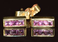 A pair of 18ct gold earrings set with three princess cut pink sapphires, 2.3g