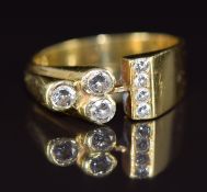 An 18ct gold ring set with seven diamonds in a bespoke design, the total diamond weight