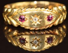 An 18ct gold ring set with a diamond and rubies in star settings, Birmingham 1911, 1.8g, size M