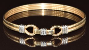 A 9ct bi-coloured gold bangle with buckle clasp, 13.1g, 5.8 x 6.8cm