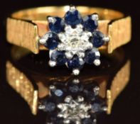 An 18ct gold ring set with a diamond surrounded by sapphires, 5,7g, size M