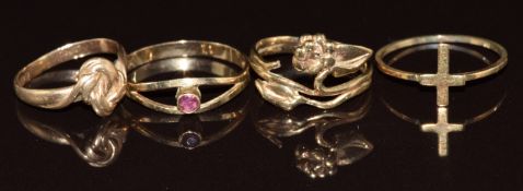 Four 9ct gold rings comprising knot, cross, garnet set and floral design, 3.5g, size G,L & M
