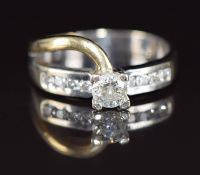 An 18ct gold bi-coloured ring set with a round cut diamond of approximately 0.4ct and further