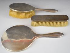 George V hallmarked silver three piece dressing table set comprising hand mirror and two brushes,
