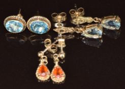 A pair of 9ct gold earrings each set with an oval topaz, a pair of 9ct gold earrings set with