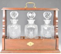 Mahogany three bottle tantalus with Edinburgh Crystal decanters, W41 x H38cm