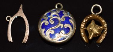 A 15ct gold charm in the form of a horse shoe and fox's head, Victorian locket set with blue enamel,