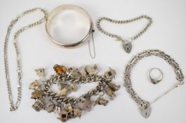 A collection of silver jewellery including bangle, charm bracelet with over twenty charms