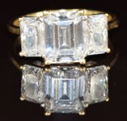 An 18ct gold ring set with three emerald cut cubic zirconia, 6.2g, size O
