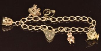 A 9ct gold charm bracelet with five 9ct gold charms including a bird in a cage, tea pot, teddy bear,