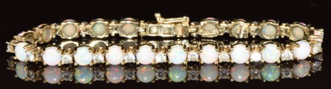 A 14k gold bracelet set with round synthetic opal cabochons and cubic zirconia, 13.9g, 17.5cm