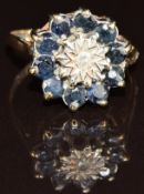 A 9ct gold ring set with a diamond surrounded by sapphires, 2.9g, size P