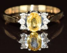 A 9ct gold ring set with an oval cut yellow sapphire and diamonds, 2.7g, size P