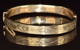 A 9ct gold bangle with chased foliate decoration, 11.7g, 5.6 x 5.2cm