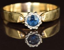 An 18k gold ring set with a round cut sapphire and two diamonds, 3g, size N