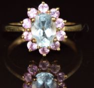 A 9k gold ring set with an oval cut aquamarine surrounded by pink sapphires, 2.7g, size N