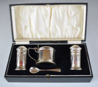 Cased George V hallmarked silver three piece cruet set with blue glass liners, Birmingham 1934,