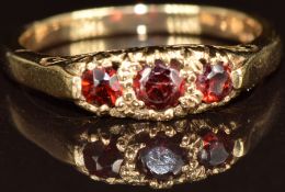 A 9ct gold ring set with three garnets, 2.9g, size O