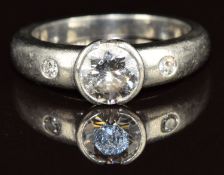 A platinum ring set with a round cut diamond of approximately 1.1ct and two smaller diamonds, 10.4g,
