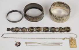 A collection of silver jewellery comprising two bangles, a christening bangle, Siam bracelet, St