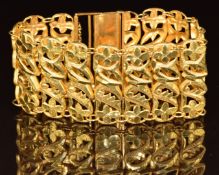 A yellow metal bracelet made up of floral and foliate links, tests as 21k, 35.7g, 17.5cm