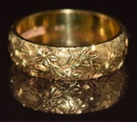 An 18ct gold wedding band / ring with engraved floral decoration, 6.2g, size L