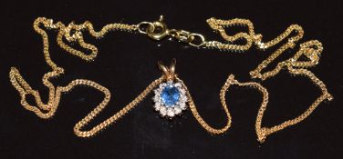 A 9ct gold pendant set with an oval cut sapphire surrounded by diamonds, on 18ct gold chain (2.7g,