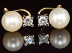 A pair of 18k gold earrings each set with a pearl and a round cut diamond of approximately 0.2ct,