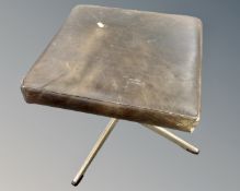 A 1970s black leather upholstered footstool on metal pedestal.