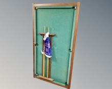 A tabletop snooker table with cue rack, cues and accessories.