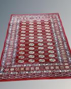 A machine made rug of Tekke design, on red ground,