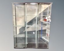 Three IKEA Detolf glass display cabinets.