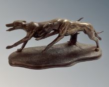 A contemporary bronzed resin figure of two greyhounds, length 29cm.
