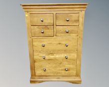 A contemporary oak seven drawer chest (width 89cm) together with an all glass mirror.