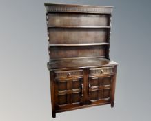 An Ercol elm and beech Welsh double door dresser in an antique finish.