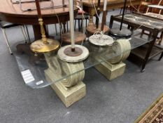 A contemporary glass topped coffee table on classical pedestals (width 130cm)