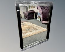 A contemporary mirror in a black frame, 86cm by 111cm.