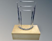 A storage box in a pine finish together with a metal towel rail.